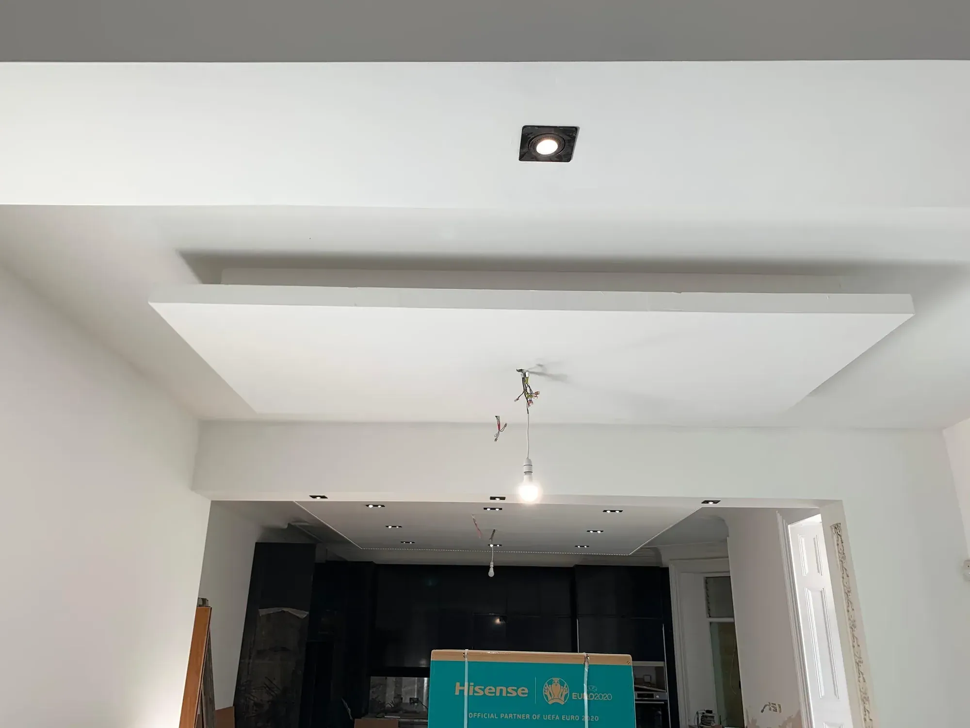 Plasterboard ceiling raft with a stepped edge above a kitchen, single downlight, pendant cable hanging