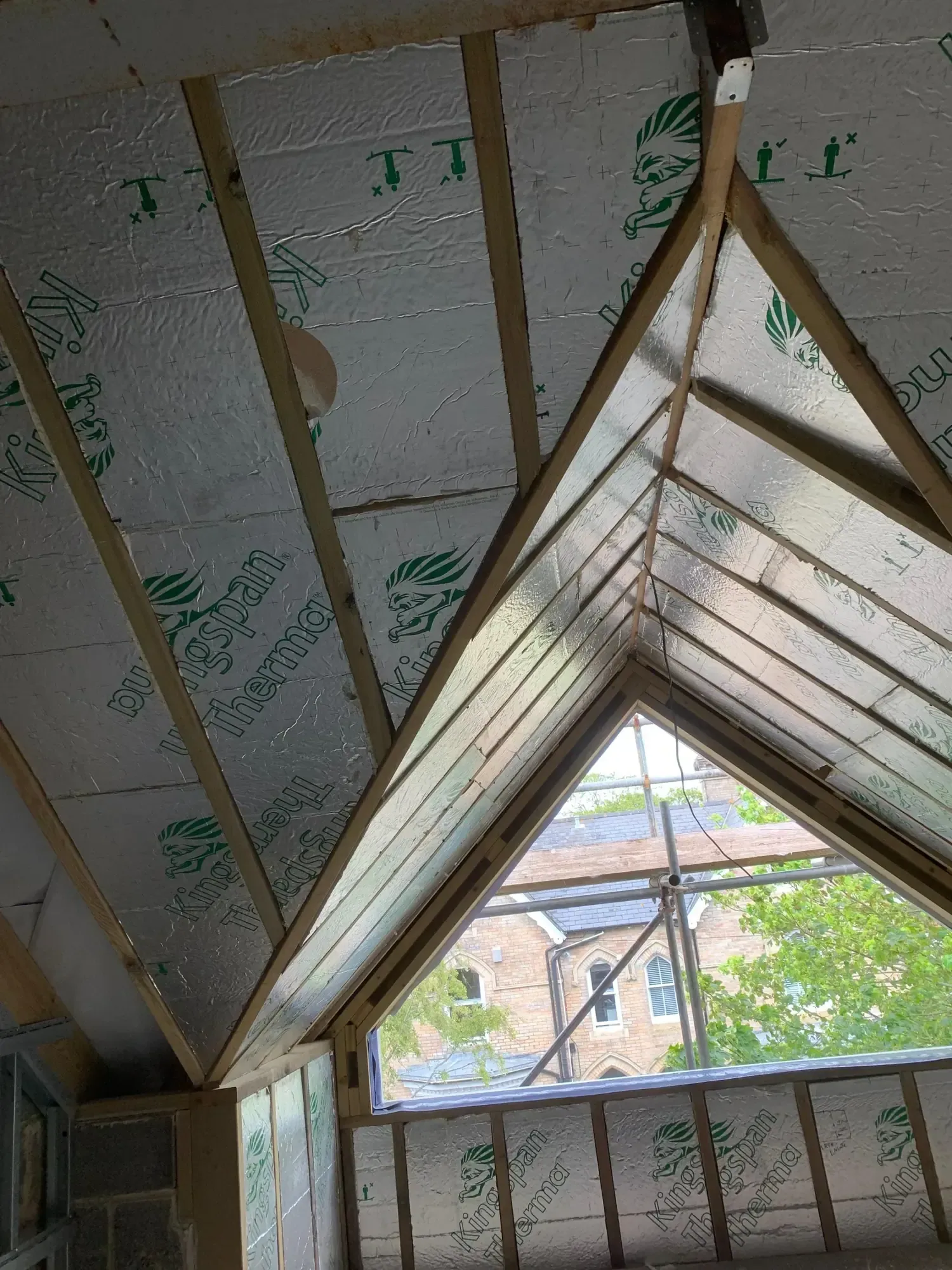 Insulation boards fitted between rafters up to the apex, window opening at the gable